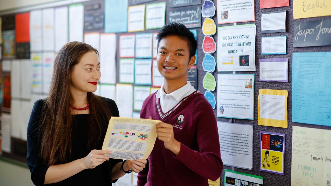 Female teacher standing with high school student