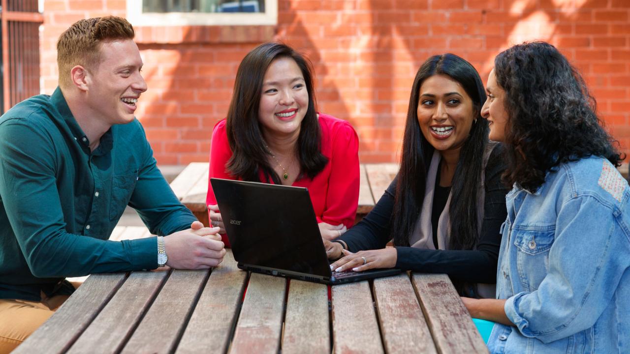 Teachers having discussion at a table outdoors