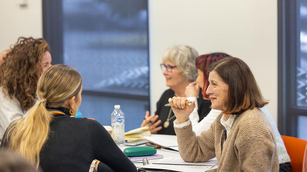 Participants seated around table in discussion during a workshop