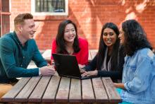 Teachers having discussion at a table outdoors