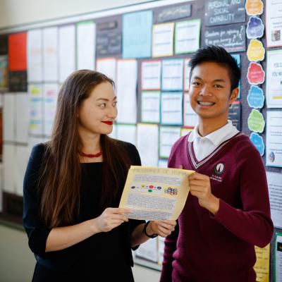 Female teacher standing with high school student