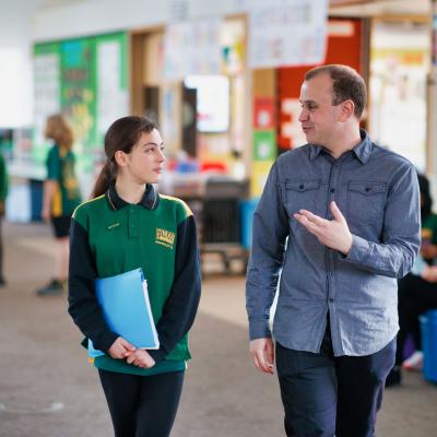 Male teacher walking with primary student