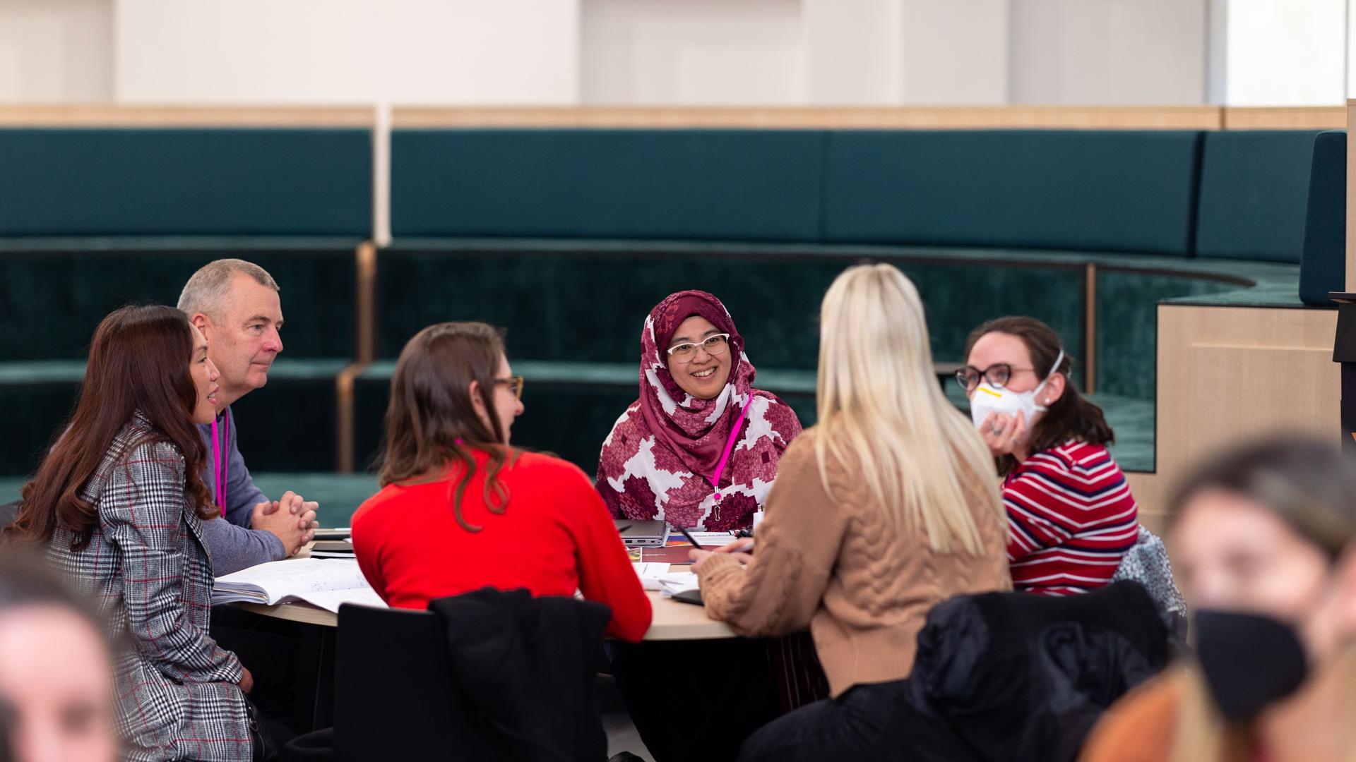 adults sitting around a table discussing 